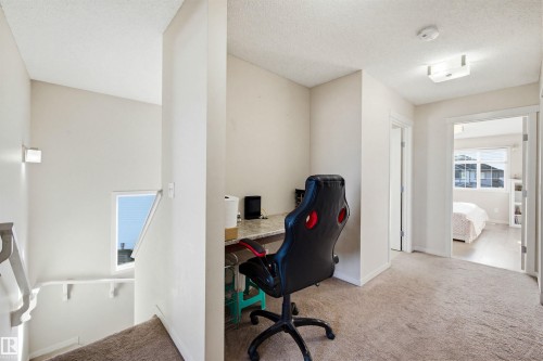 This area features neutral-toned carpeting, a built-in desk space, and a ceiling-mounted light fixture - 2812 16 Avenue, Edmonton, AB - Indoor Photo Showing Other Room