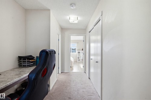 Hallway with light-colored carpeting, a built-in desk area, and a closet with bi-fold doors - 2812 16 Avenue, Edmonton, AB - Indoor Photo Showing Office