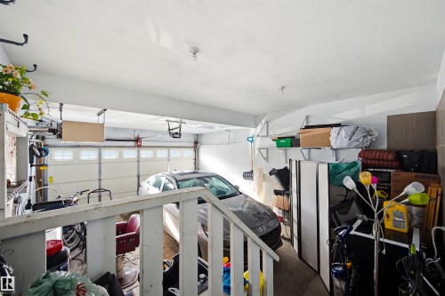 The property features a garage with a white garage door, overhead lighting, and shelving for storage - 2812 16 Avenue, Edmonton, AB - Indoor Photo Showing Garage