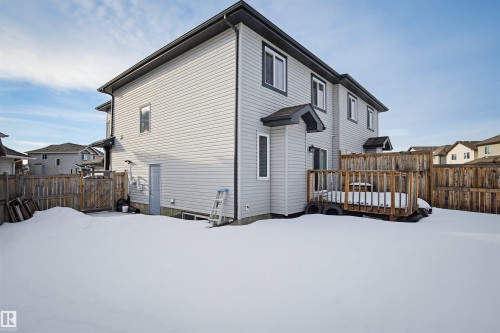 The property features light-colored horizontal siding and a wooden fence enclosing the yard - 2812 16 Avenue, Edmonton, AB - Outdoor With Exterior