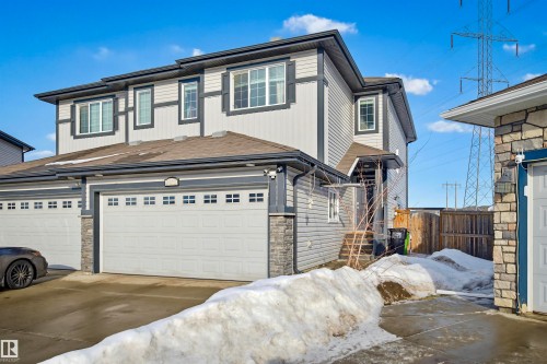 This property features a two-story exterior with light-colored siding and dark trim, complemented by stone accents - 2812 16 Avenue, Edmonton, AB - Outdoor