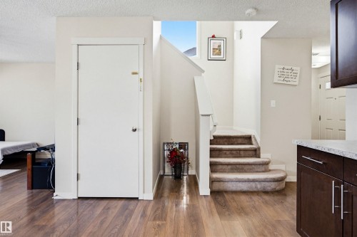 The property features durable wood-look flooring and a carpeted staircase with white risers and railings - 2812 16 Avenue, Edmonton, AB - Indoor Photo Showing Other Room