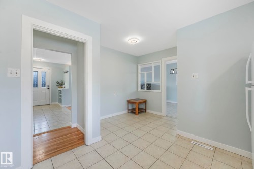 The property features light blue walls and off-white tiled flooring throughout the space - 15704 91 Avenue, Edmonton, AB - Indoor Photo Showing Other Room