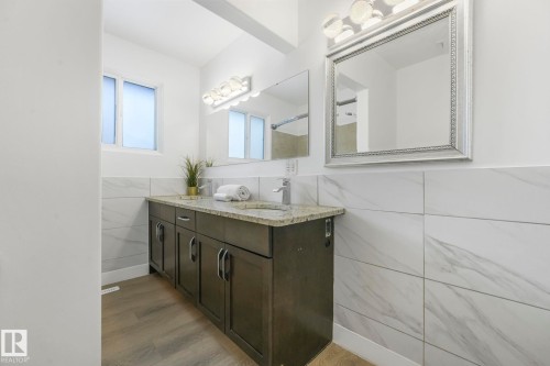 Bathroom featuring a double vanity with dark cabinetry and a light-colored countertop - 15704 91 Avenue, Edmonton, AB - Indoor Photo Showing Bathroom