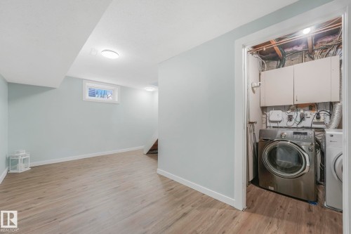 This versatile area features light-toned flooring and a window providing natural light - 15704 91 Avenue, Edmonton, AB - Indoor Photo Showing Laundry Room