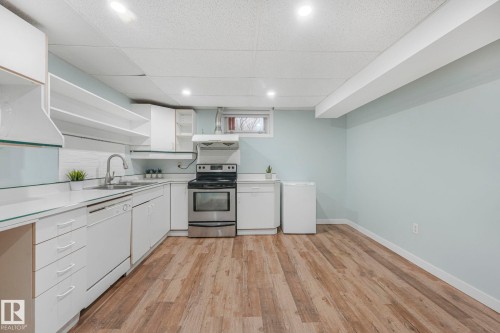 The kitchen features white cabinetry, white countertops, and a stainless steel oven - 15704 91 Avenue, Edmonton, AB - Indoor