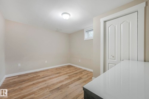 Room with light wood-style flooring, a window, and a white bi-fold closet door - 15704 91 Avenue, Edmonton, AB - Indoor Photo Showing Other Room