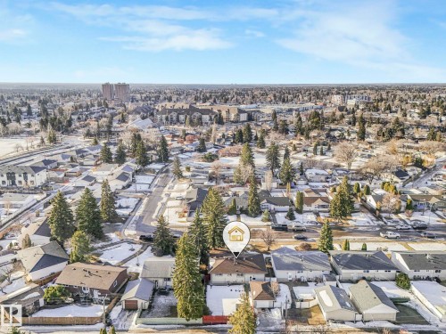Aerial view showcasing the property within a residential neighborhood featuring mature trees and a clear sky - 15704 91 Avenue, Edmonton, AB - Outdoor With View