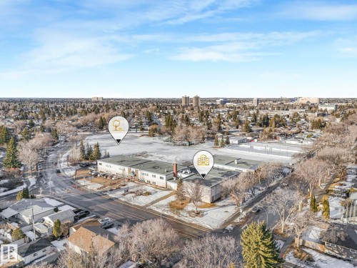 Aerial view of the property and its surrounding area, featuring paved roads, mature trees, and a clear sky - 15704 91 Avenue, Edmonton, AB - Outdoor With View