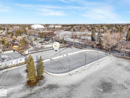 This aerial view highlights the proximity of the property to a well-maintained outdoor ice rink and expansive snow-covered grounds - 15704 91 Avenue, Edmonton, AB - Outdoor With View