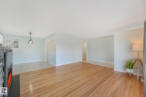 This interior features hardwood flooring throughout the main area, with tile flooring in the dining area - 15704 91 Avenue, Edmonton, AB - Indoor Photo Showing Other Room
