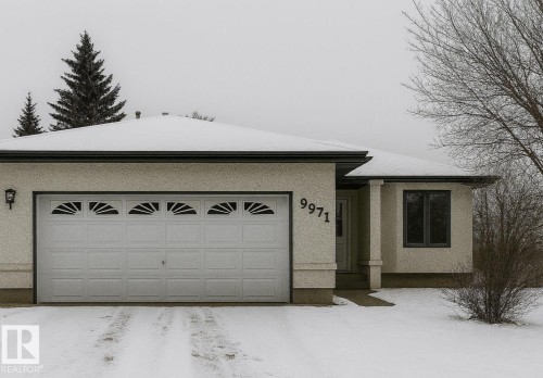 The property features an attached garage with decorative windows and a paved driveway - 9971 178 Avenue, Edmonton, AB - Outdoor