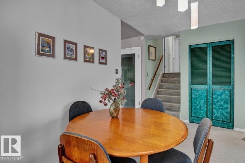 Dining area featuring a round wood table and a patterned bi-fold door - 3523 18A Avenue, Edmonton, AB - Indoor Photo Showing Dining Room