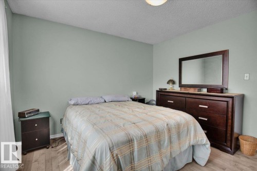 This inviting room features light-colored walls and wood flooring, creating a bright and airy atmosphere - 3523 18A Avenue, Edmonton, AB - Indoor Photo Showing Bedroom
