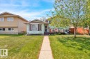 The property features a well-maintained lawn, a paved walkway leading to the entrance, and a front porch - 3523 18A Avenue, Edmonton, AB  - Outdoor With Facade 