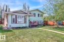 The property features a well-maintained lawn, a paved walkway, and a spacious deck with railing - 3523 18A Avenue, Edmonton, AB  - Outdoor 