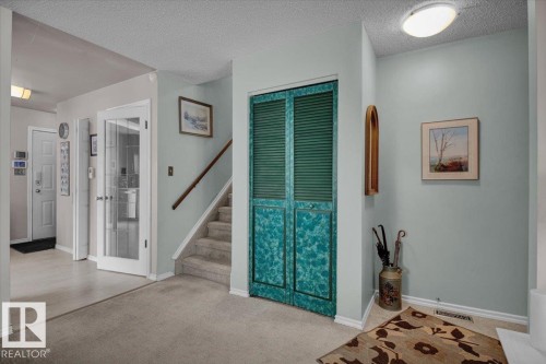 Entryway featuring carpeted flooring and a staircase with a wooden handrail - 3523 18A Avenue, Edmonton, AB - Indoor Photo Showing Other Room