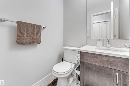 Bathroom featuring a modern vanity with a white countertop, a white toilet, and a large mirror - 2244 21 Avenue, Edmonton, AB - Indoor Photo Showing Bathroom