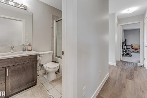Bathroom featuring a vanity with a white countertop, a mirror, and a shower with a clear glass enclosure - 2244 21 Avenue, Edmonton, AB - Indoor Photo Showing Bathroom