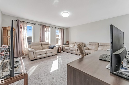 Bright living area featuring light-colored carpet flooring and multiple windows providing natural light - 2244 21 Avenue, Edmonton, AB - Indoor Photo Showing Living Room