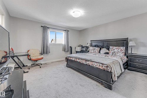 Bedroom with light gray walls, light gray carpet, and a window with gray curtains - 2244 21 Avenue, Edmonton, AB - Indoor Photo Showing Bedroom