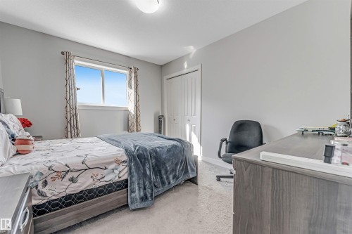 A bright room featuring a window with natural light, a bi-fold closet, and neutral-toned carpeting - 2244 21 Avenue, Edmonton, AB - Indoor Photo Showing Bedroom