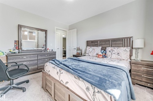 This bedroom features light gray walls and a light-colored carpet, creating a bright and airy atmosphere - 2244 21 Avenue, Edmonton, AB - Indoor Photo Showing Bedroom