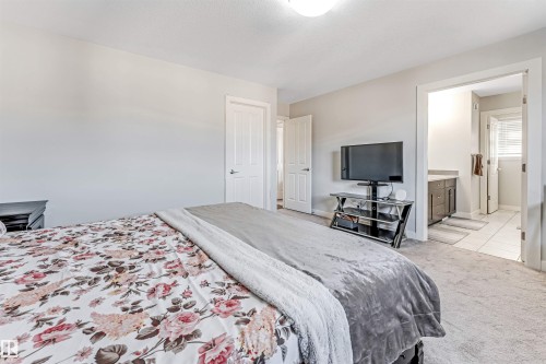 This bedroom features light-colored walls and soft carpet flooring, creating a serene atmosphere - 2244 21 Avenue, Edmonton, AB - Indoor Photo Showing Bedroom