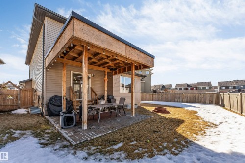 The property features a spacious backyard with a wooden fence and a partially covered patio area - 2244 21 Avenue, Edmonton, AB - Outdoor