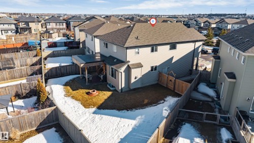 The property features an extensive fenced yard with a partially covered patio and a fire pit - 2244 21 Avenue, Edmonton, AB - Outdoor