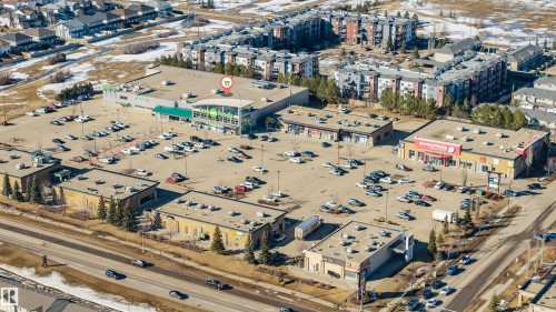 Aerial view highlighting a commercial development with a large parking area, surrounded by residential buildings - 2244 21 Avenue, Edmonton, AB - Outdoor With View