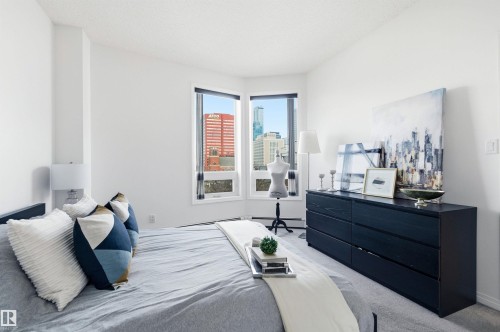 Room featuring large windows providing city views, white walls, and light-colored carpeting - 601 10504 99 Avenue, Edmonton, AB - Indoor Photo Showing Bedroom