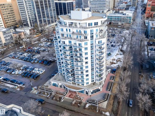 Modern high-rise building with a distinctive curved facade and numerous balconies, situated in an urban setting with surrounding city buildings and street views - 601 10504 99 Avenue, Edmonton, AB - Outdoor
