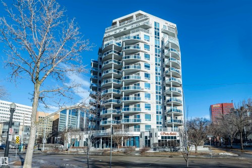 The property features a distinctive high-rise building with numerous balconies, each fitted with clear glass railings - 601 10504 99 Avenue, Edmonton, AB - Outdoor With Facade