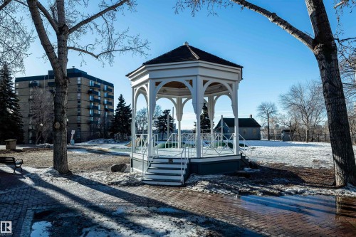 Community park featuring a white gazebo with a dark roof, surrounded by trees and a paved walkway - 601 10504 99 Avenue, Edmonton, AB - Outdoor