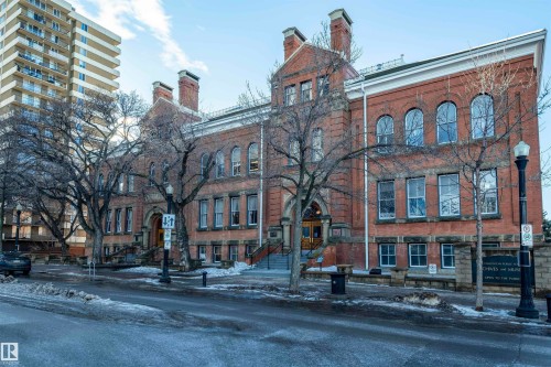 The property features a brick exterior with prominent chimneys and arched windows, showcasing architectural details - 601 10504 99 Avenue, Edmonton, AB - Outdoor With Facade