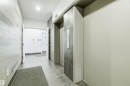 The property features a hallway with light-toned tiled walls and flooring, leading towards an open doorway - 601 10504 99 Avenue, Edmonton, AB  - Indoor Photo Showing Other Room 