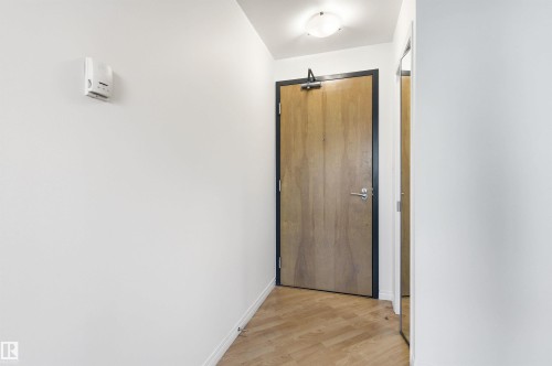 Entryway featuring light hardwood flooring, a ceiling-mounted light fixture, and a wooden door with a dark frame - 601 10504 99 Avenue, Edmonton, AB - Indoor Photo Showing Other Room