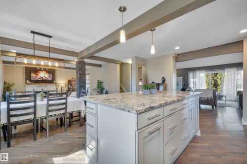 The kitchen features a large island with a light-colored granite countertop and ample drawer and cabinet storage - 8807 31 Avenue, Edmonton, AB - Indoor Photo Showing Other Room