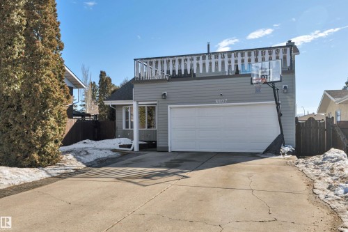 The property features a private driveway leading to an attached garage with a white door - 8807 31 Avenue, Edmonton, AB - Outdoor