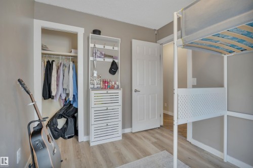 This room features a closet with a hanging rail and shelving, light gray walls, and light-colored flooring - 8807 31 Avenue, Edmonton, AB - Indoor