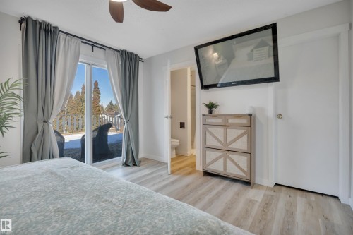 This property features light-colored flooring, a sliding glass door leading to the outdoors, and a ceiling fan - 8807 31 Avenue, Edmonton, AB - Indoor Photo Showing Bedroom