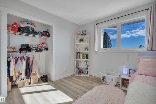 Room featuring light-colored flooring, a window providing natural light, and a built-in closet with shelving and hanging space - 8807 31 Avenue, Edmonton, AB - Indoor
