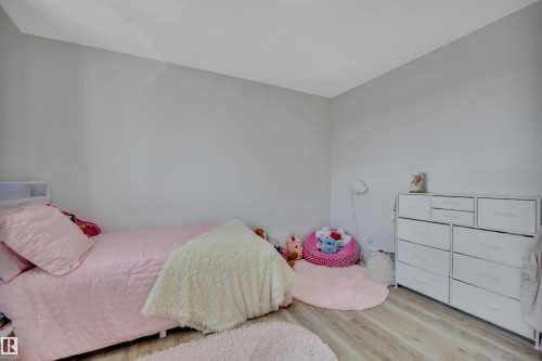 This room features light-colored walls, light-toned flooring, and a white dresser with drawers - 8807 31 Avenue, Edmonton, AB - Indoor Photo Showing Bedroom