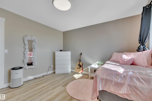 This room features wood-look flooring and light grey walls, creating a neutral backdrop - 8807 31 Avenue, Edmonton, AB - Indoor Photo Showing Bedroom