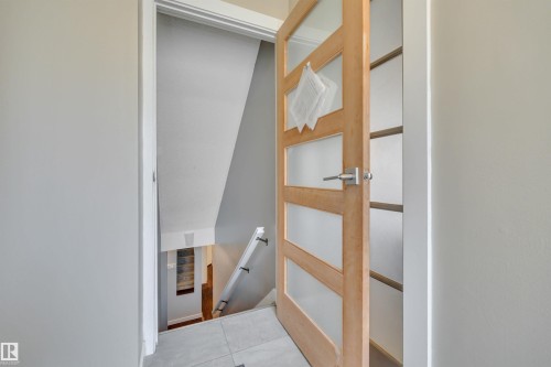 Modern interior door with frosted glass panels and a contemporary handle - 8807 31 Avenue, Edmonton, AB - Indoor Photo Showing Other Room