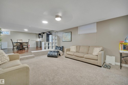 Spacious lower level with carpeted living area and a raised dining area featuring hardwood flooring - 8807 31 Avenue, Edmonton, AB - Indoor Photo Showing Other Room