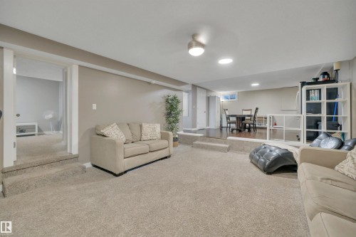 Expansive lower level living area featuring carpeted flooring, neutral wall tones, recessed lighting, and a raised section with wood-look flooring - 8807 31 Avenue, Edmonton, AB - Indoor
