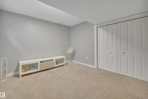 This room features light grey walls and light-colored carpeting, creating a bright and neutral atmosphere - 8807 31 Avenue, Edmonton, AB - Indoor Photo Showing Other Room
