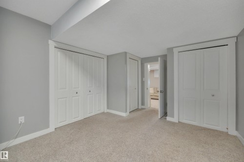 Room featuring light gray walls, white trim, and light-colored carpet - 8807 31 Avenue, Edmonton, AB - Indoor